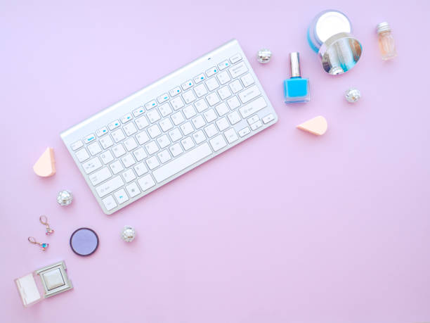 istock Keyboard and makeup tools and cosmetic products around it isolated on a purple background. 1192170415