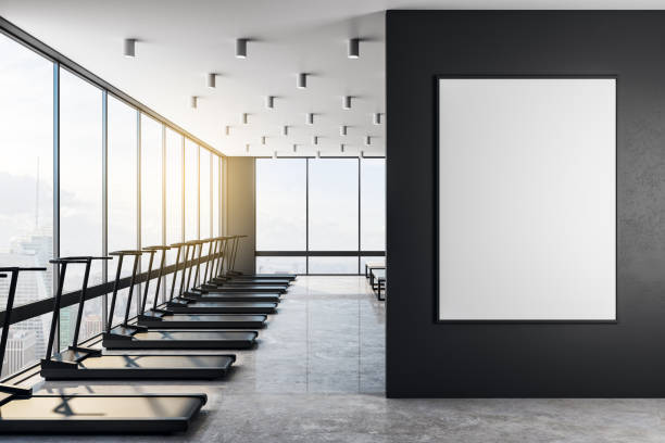 istock Blank white poster on black wall in modern gym at sunrise. 1192170601