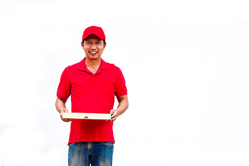 Delivery concept: Men in red shirts and hats are pizza dealers, carrying pizza boxes ready to deliver products to customers.