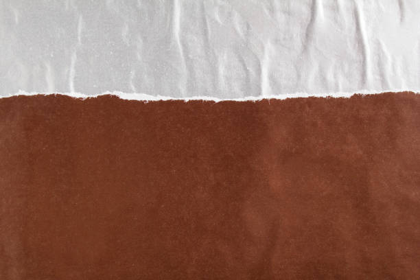 istock Dark brown and silver grey crumpled, torn and peeling gloss paper posters texture background. Can be used for text. 1192175440