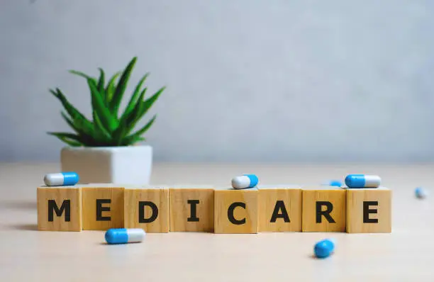 Photo of MEDICARE word made with building blocks, medical concept background