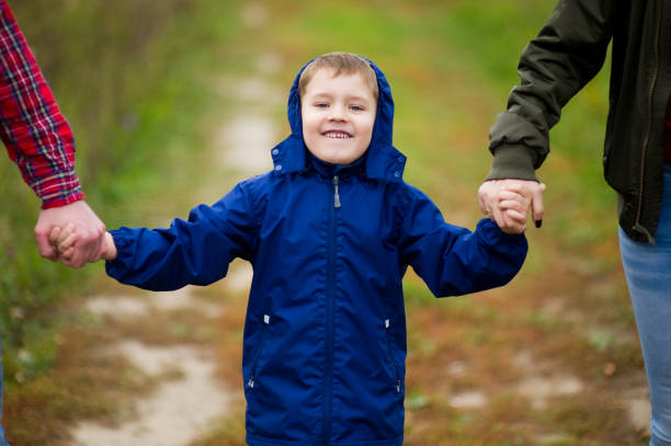 istock Smiling kid held in hands by mom and dad 1192185637