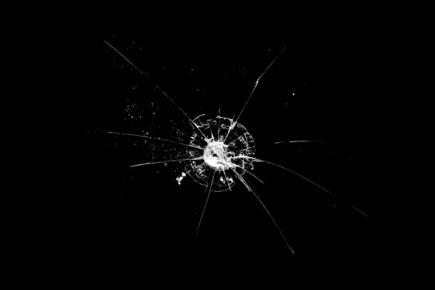 istock hole in the glass with cracks isolated on a black background 1192185679