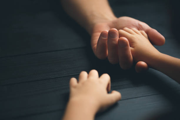 istock Adult hands holding kid hands 1192190341