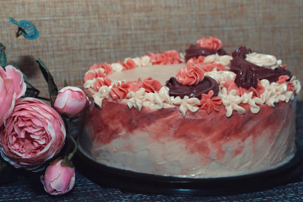 istock Pink cake with cream flowers on a dark background 1192191987