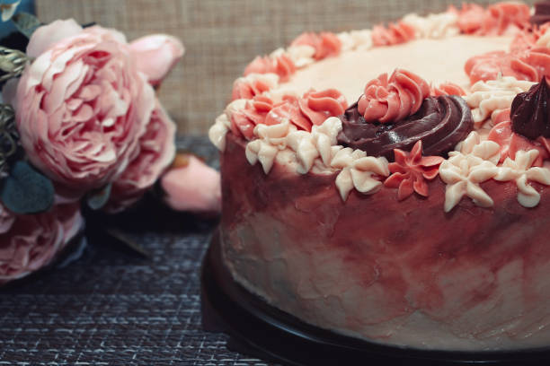 istock Pink cake with cream flowers on a dark background 1192191990
