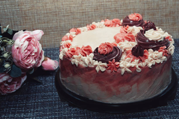 istock Pink cake with cream flowers on a dark background 1192191997