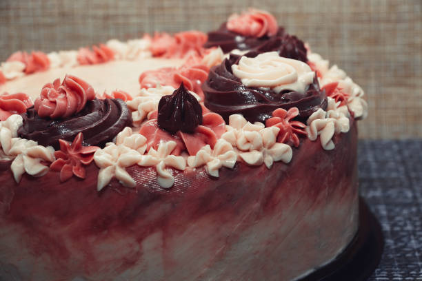 istock Pink cake with cream flowers on a dark background 1192192013