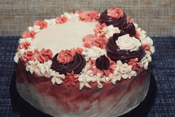 istock Pink cake with cream flowers on a dark background 1192192029