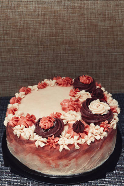 istock Pink cake with cream flowers on a dark background 1192192036