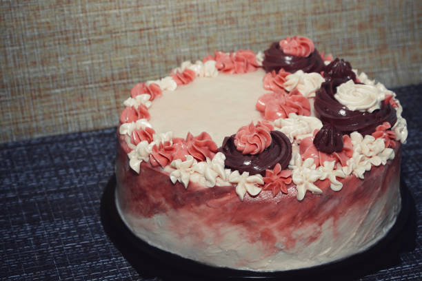 istock Pink cake with cream flowers on a dark background 1192192041