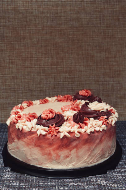istock Pink cake with cream flowers on a dark background 1192192053