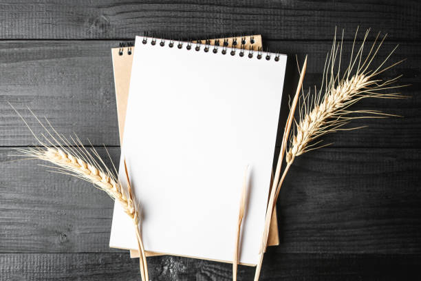 istock Notebook on black background with golden spikelets 1192195492
