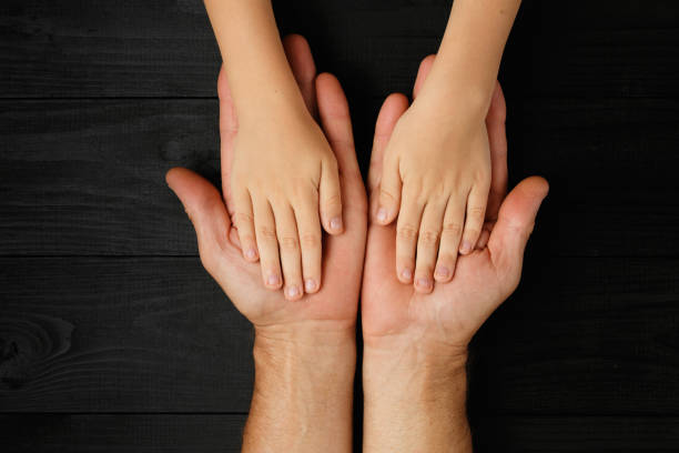 istock Adult hands holding kid hands 1192196218