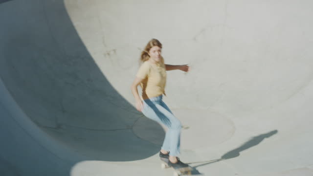 Handheld shot of a skater girl ripping in the pool bowl