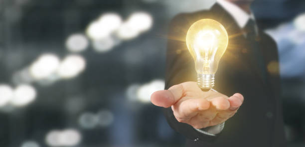 istock Hand of holding illuminated light bulb 1192197816