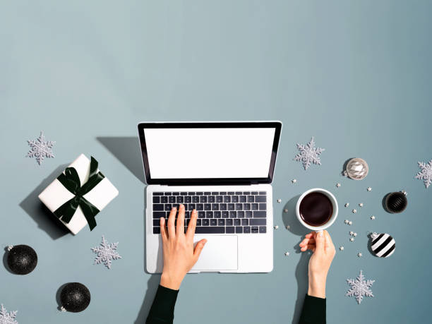 istock Christmas ornaments with person using a laptop computer 1192199145