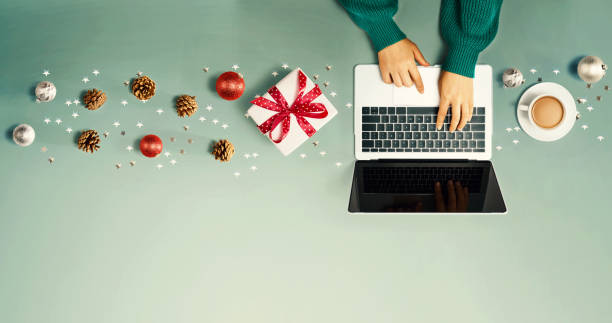 istock Christmas ornaments with person using a laptop computer 1192200208