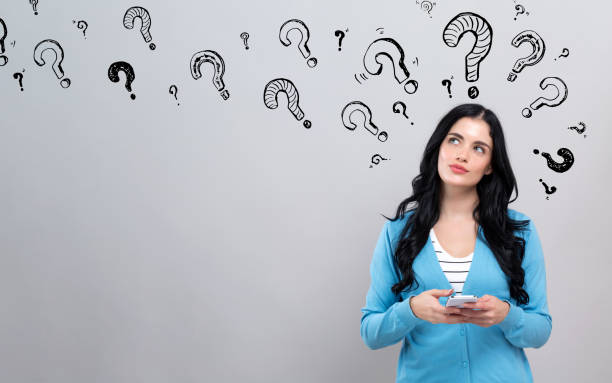 istock Question marks with woman holding a smartphone 1192203097