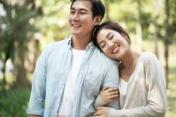 istock loving young asian couple relaxing in park 1192207441