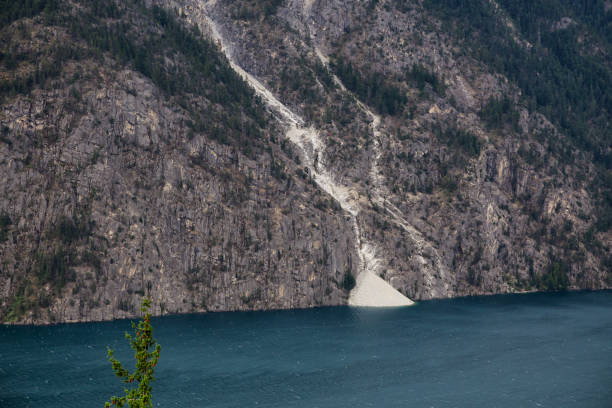Landslide off a rocky mountain into Anderson Lake Landslide off a rocky mountain into Anderson Lake during a cloudy summer day. Located near Lillooet, BC, Canada. pemberton town stock pictures, royalty-free photos & images