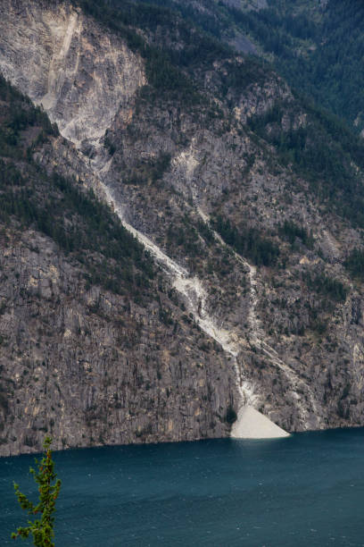 Landslide off a rocky mountain into Anderson Lake Landslide off a rocky mountain into Anderson Lake during a cloudy summer day. Located near Lillooet, BC, Canada. pemberton town stock pictures, royalty-free photos & images