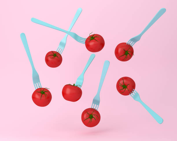 istock Creative layout of tomato with a fork floating on pastel pink background. minimal idea food concept. 1192216532