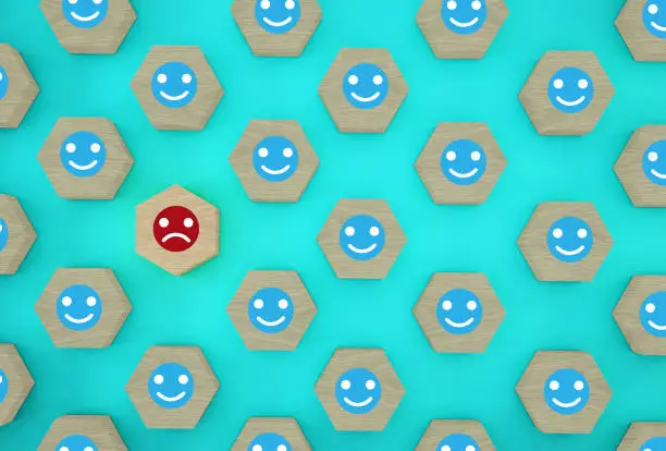 Abstract of face emotion happiness and sadness, Unique, think different, individual and standing out from the crowd concept. Wooden hexagon with icon on blue background.