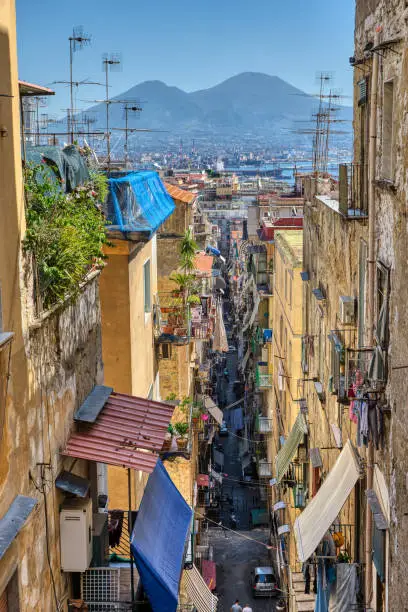 Small alleyway in the old town of Naples with Mount Vesuvius in the back