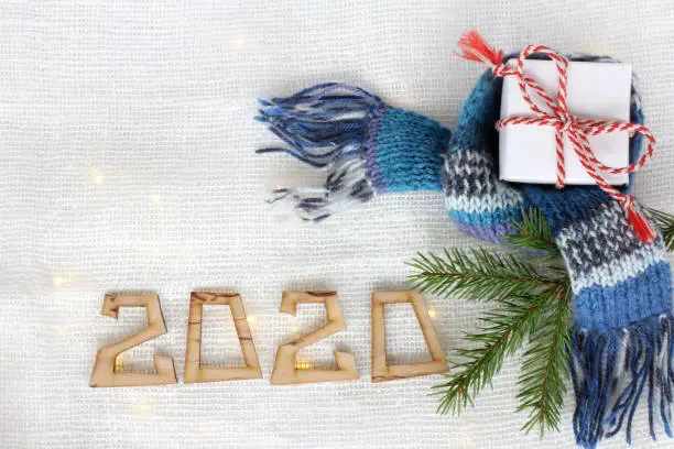 gift, spruce branch and scarf on the background with lights and a number