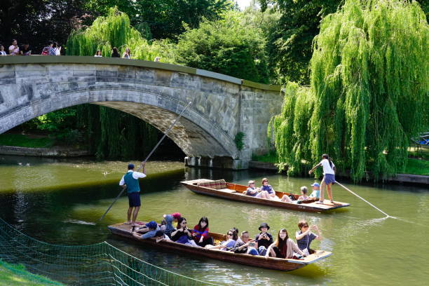 Cambridge, UK - June 6th, 2018; Punting on the river Cam through the colleges and universities of Cambridge city, UK is a huge tourist attraction for both young and old alike and a source of income for students who act as both punters and tour guides.