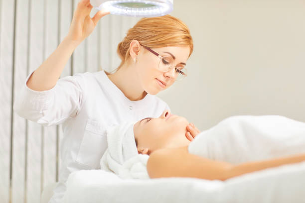 istock A cosmetologist makes a face mask to a patient 1192227407