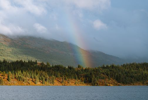 Rainbow from lake in Alaskan wilderness during autumn sunset