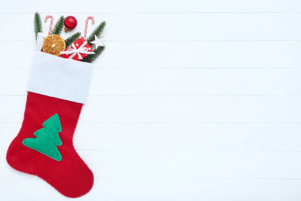 istock Red stocking with christmas ornaments on white wooden table 1192231684