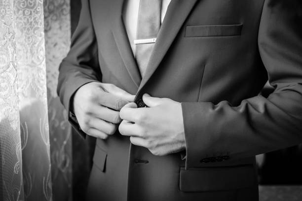 istock Black and white picture: a man buttons his jacket 1192232834