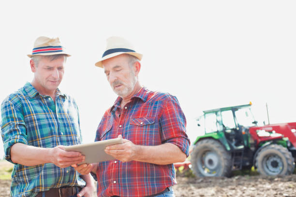 istock Farmers discussing over digital tablet in field 1192248324