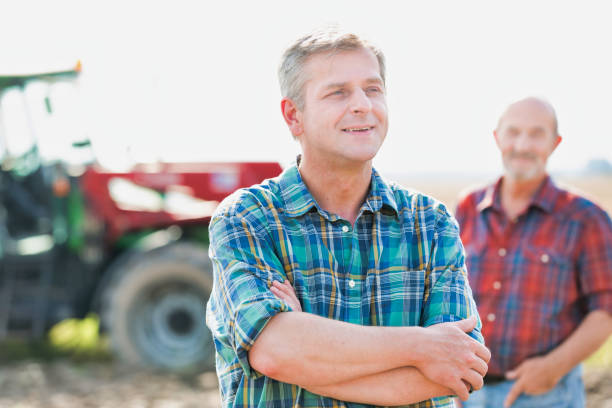 istock Farmers standing in field against tractor 1192251667