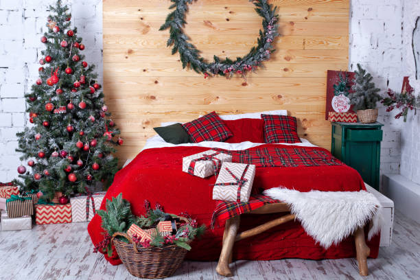 istock New Year decorated bedroom. Spacious rustic white bedroom with decorated Christmas tree and Christmas wreath on wall. Xmas in morning bedroom. Double bed In christmas Interior on wood wall background 1192254766