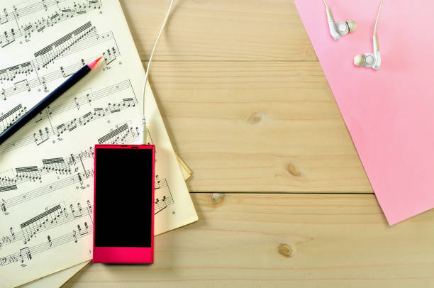 smart-phone y partituras musicales en la mesa - beautiful red pink wood fotografías e imágenes de stock