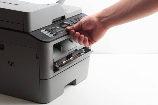 istock Hand press button on panel of printer. printer scanner laser office copy machine supplies start concept 1192258812