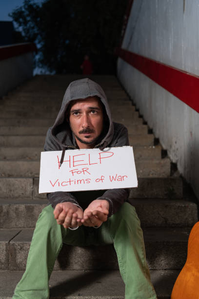 istock War Veteran is Sitting on the Stairs and Begging for Help 1192259283