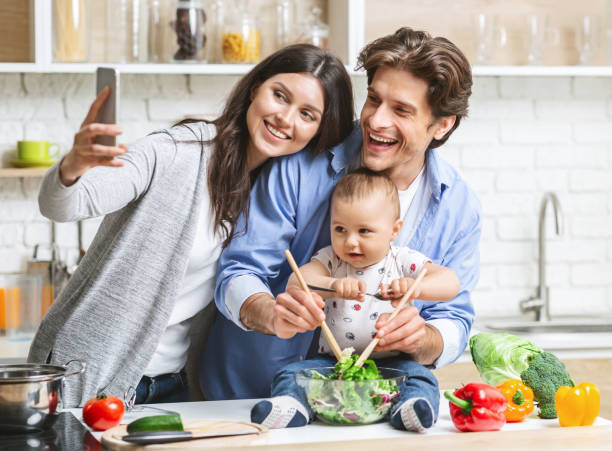 istock Mother taking selfie with baby son and husband at kitchen 1192259305