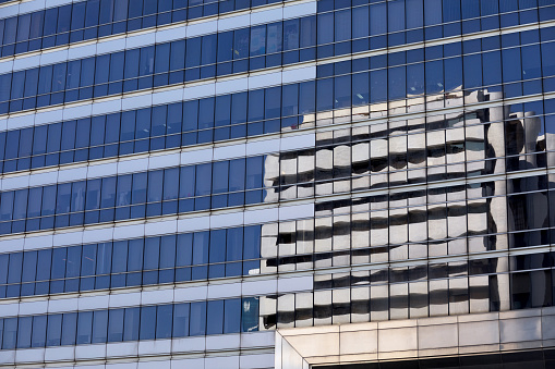 Reflected office building in glassy facade in Bangkok at Sathon Square