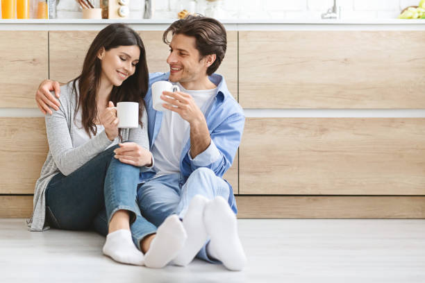 istock Happy millennial couple resting on kitchen floor with hot cups 1192259893