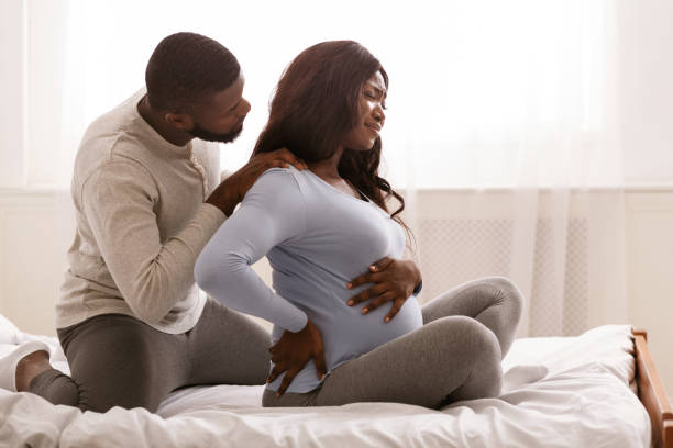 背中の痛みに苦しむ妊婦、彼女の肩をマッサージする男性 - human pregnancy backache massaging back ストックフォトと画像