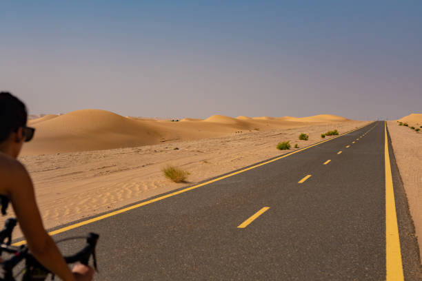 cycliste brouillé à la route de désert - sol caractéristiques dune construction photos et images de collection