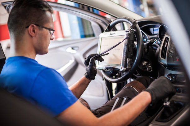istock Automobile computer diagnosis. Car mechanic repairer looks for engine failure 1192263014