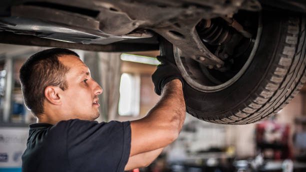 istock Auto mechanic repairer checking condition under car on vehicle lift 1192263696