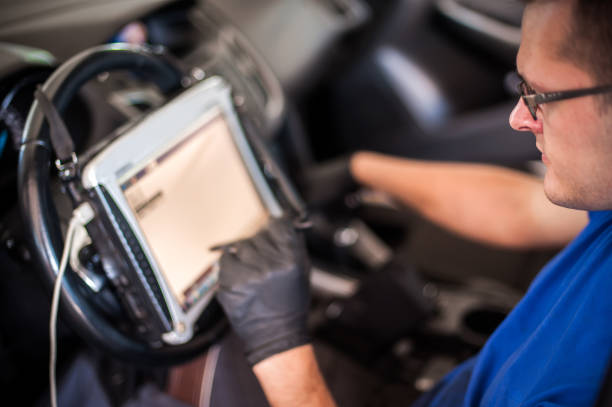 istock Automobile computer diagnosis. Car mechanic repairer looks for engine failure 1192263843