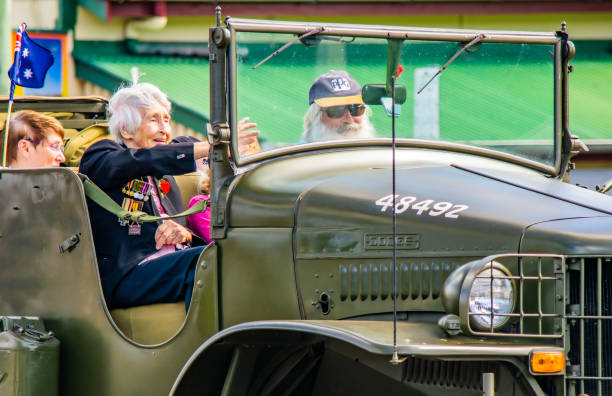 close-up of old female world war 2 veteran waving at crowd from a vintage military jeep during anzac day parade in cooroy, queensland - car individuality military 4x4 imagens e fotografias de stock